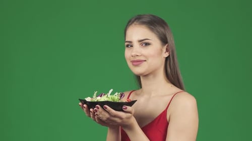 Young Woman Enjoying a Healthy Salad on Green Screen