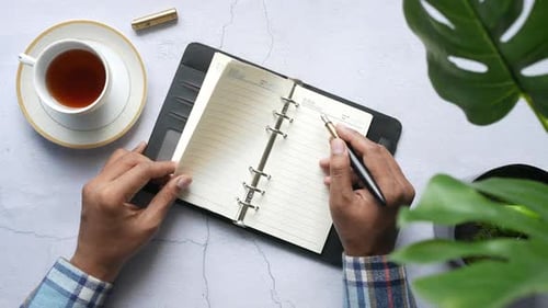 Top View of Man Hand Writing with Fountain Pen on Notepad
