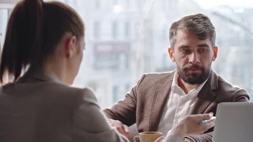 Businessman Listening to Colleague at Coffee Break