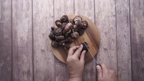 Slicing Brown Mushrooms on Wooden Board
