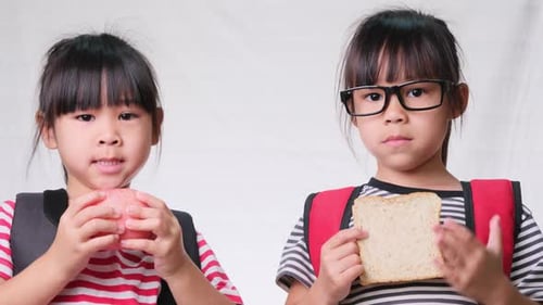 Two Young Girls Holding Lunch Food