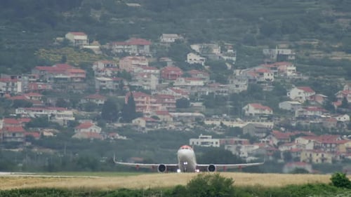 An Airplane Takes Off From an Airport Runway in a Cityscape