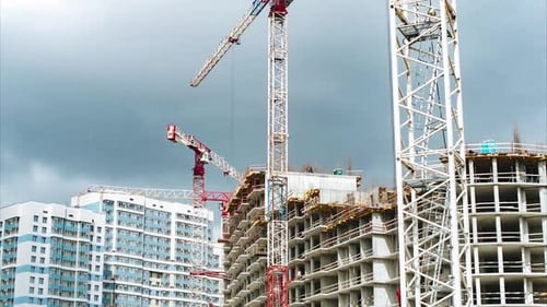 Las grúas torre altas operan la construcción de pisos superiores de la casa