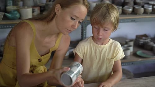 Woman Teaching Boy Pottery in Workshop