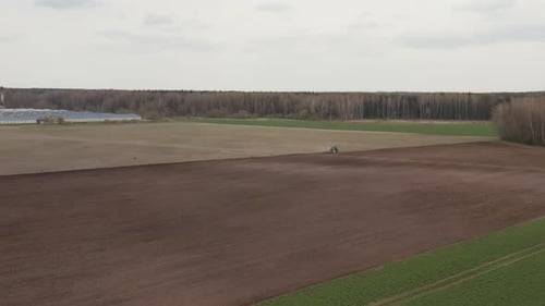 Farm Field with The Plowing Tractor