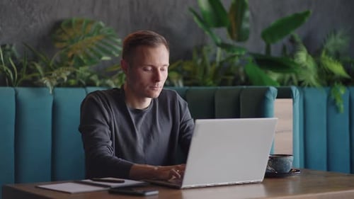 Beautiful Male Developer or Student Working Studying By Laptop in Cafe