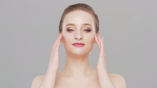 Studio portrait of young, beautiful and natural woman over grey background.