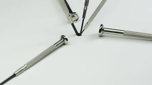 Extreme Close Up of Miniature Screwdrivers Repairing a Screw