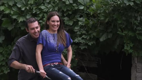 Slow motion, tracking shot of a couple riding a bicycle together.