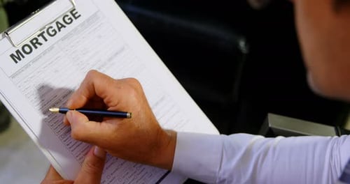 Adviser checking mortgage form in office