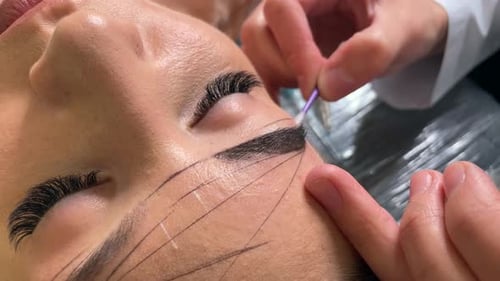 Woman having eyebrows cleaned with cotton swab