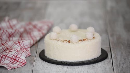 Hand Decorating Coconut Cake with Nuts and Balls