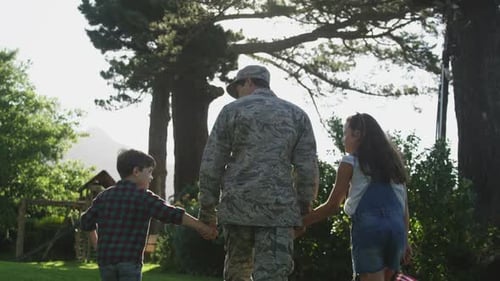 Service Member Walks with Children in Sunny Rural Setting