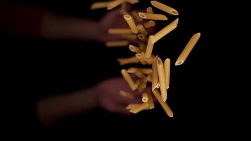 Person Hand Throws Upward Raw Yellow Penne Pasta Macro