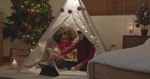 Children Sharing Christmas Cheer in Cozy Tent