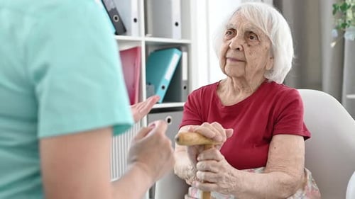 Senior Woman Talking to Healthcare Worker With Cane