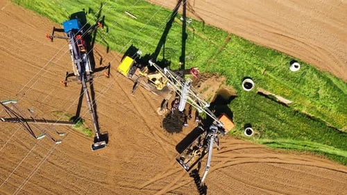 Electrical Pylon Construction Site in Rural Field Aerial View