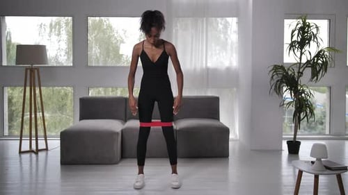 Young Woman Exercising with Resistance Band at Home