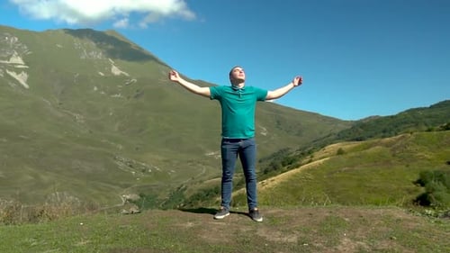 Man Enjoying Scenic Mountain View with Open Arms