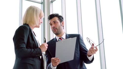 Two Business People Talk Project Strategy at Office