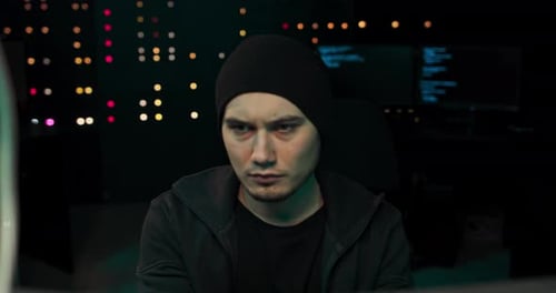 A Young Tired Hacker with Dark Circles Under His Eyes Breaks Into the Company's Data
