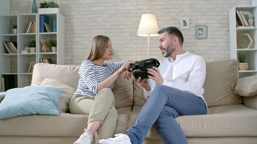 Couple Discussing VR Headset on Living Room Couch