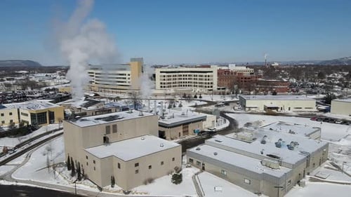 Panoramic view over large building complex in winter. Snow covered ground. Brilliant blue sky.