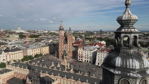 Aerial drone view of St. Mary's church and clock tower in main market square at sunny day. Krakow, P