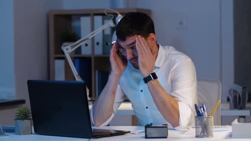 Businessman with Laptop Working at Night Office