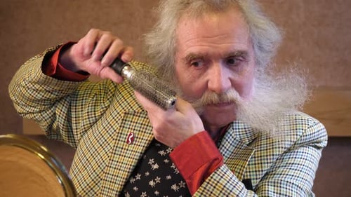 Un anciano peina su barba en forma