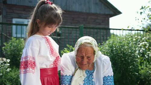 An Old Grandmother is Sitting on the Street and Reading a Book