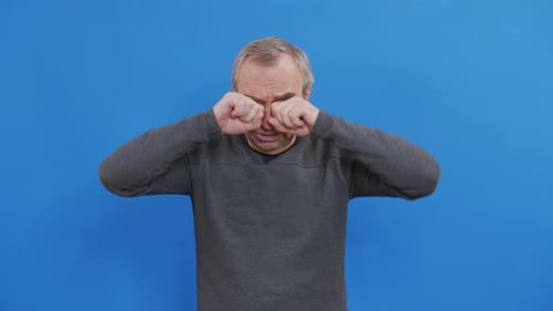 Adult Man Rubs his Eyes
