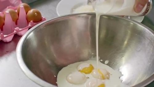 Pouring Milk into Bowl of Egg Yolks