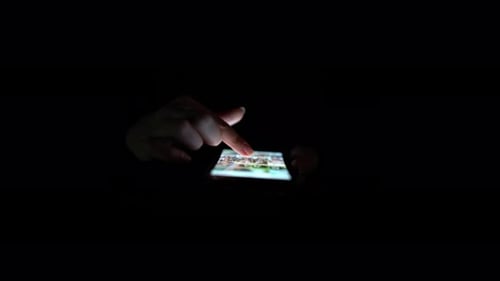 Die
Hände der Person überprüfen das Handy. Nahaufnahme. Schwarzer Hintergrund
