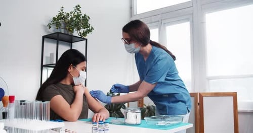 Medical Professional Giving Injection to Young Woman