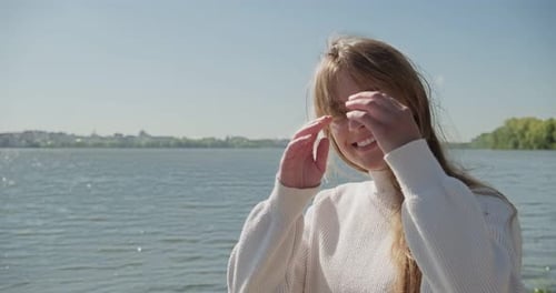 Woman Smiling by Lake in Sunny Weather