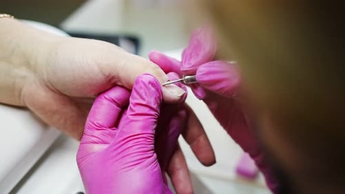 Manikürekünstler macht professionelle Maniküre im Schönheitssalon