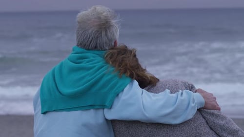 Senior couple sit at beach together