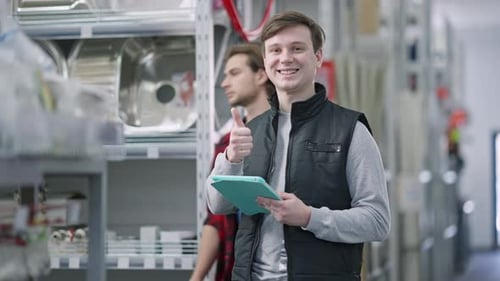 Smiling Man With Tablet Gives a Thumbs Up