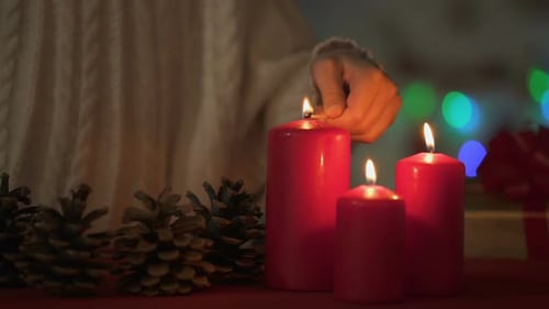 Woman Lights Candles for a Cozy Christmas Celebration