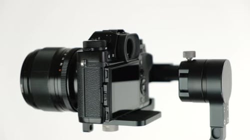Camera Rotating on Stabilizer against White Background