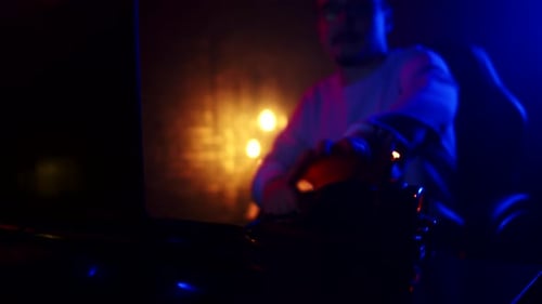 Young Adult Gamer Puts on Headphones at Computer