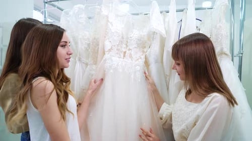 Young Women Choosing Wedding Dresses in Fashion Boutique