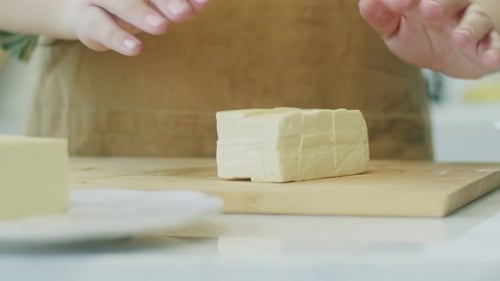 Hands Preparing Tofu on Cutting Board