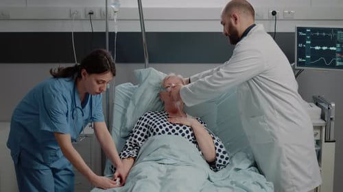 Medical Staff Attending to Patient in Hospital Bed