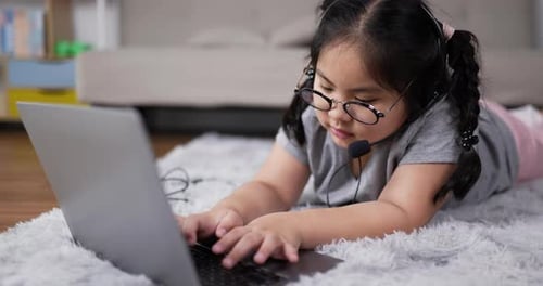 Girl with Headset Using Laptop on Rug