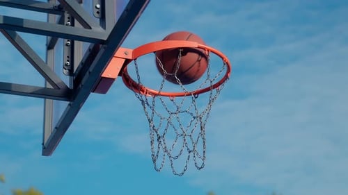 Basketball Swish Through Hoop Against a Blue Sky