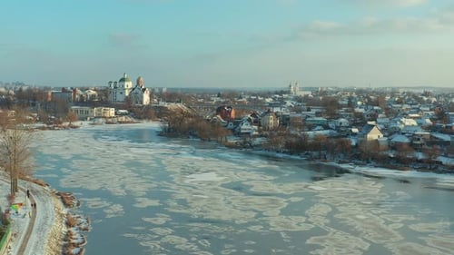 Beautiful winter flight over the city. Top view of the river that freezes. Ice.