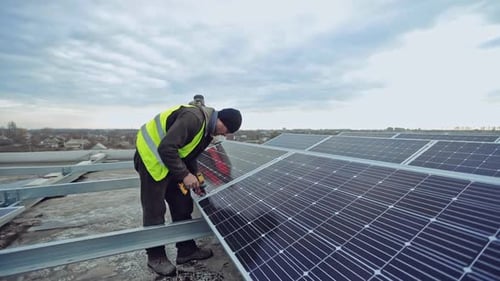 Un technicien avec perceuse renforce le panneau solaire