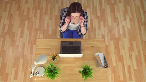 Woman Working at Computer Puts Head Down
